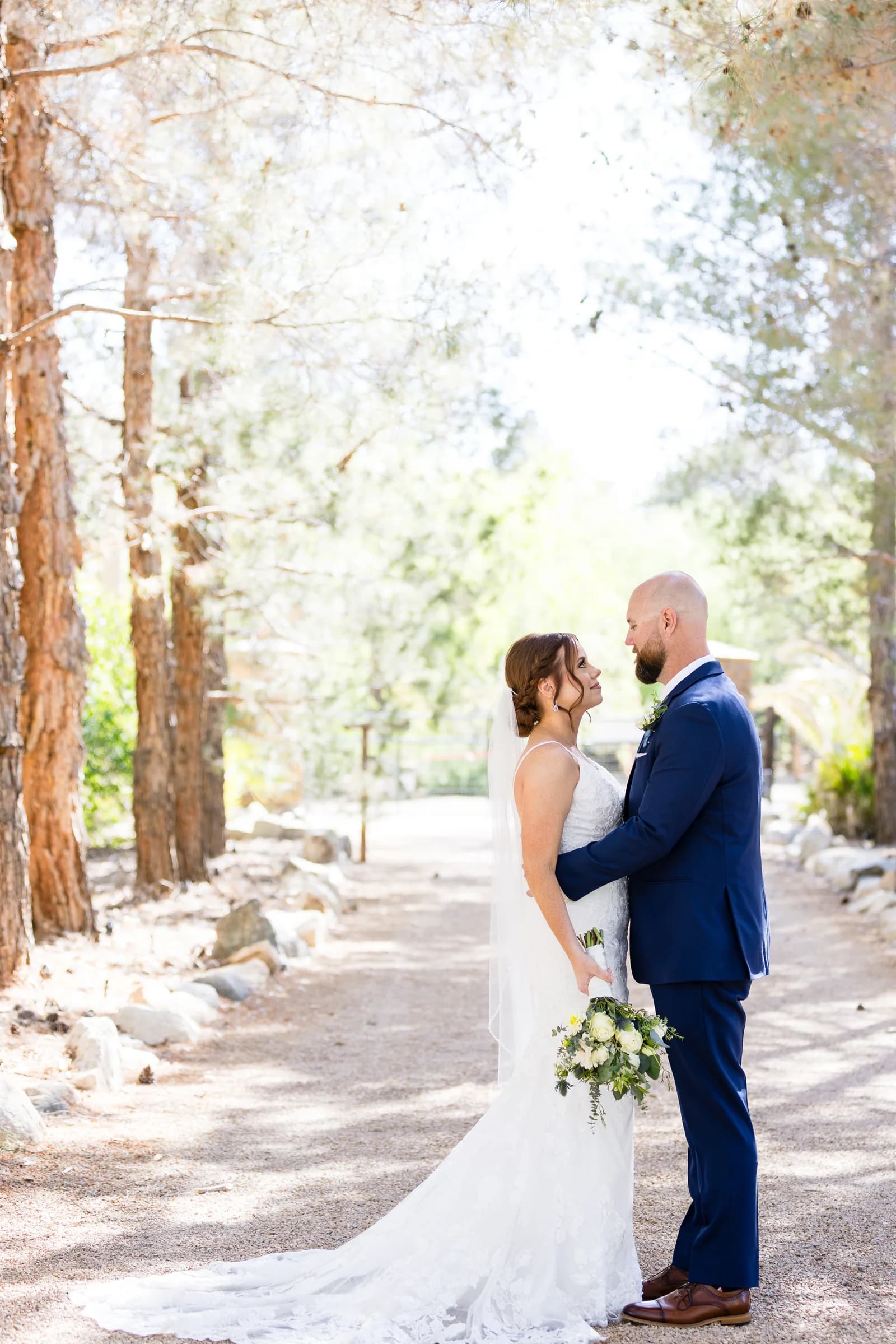 A couple walking a tree-lined garden path in golden-hour light