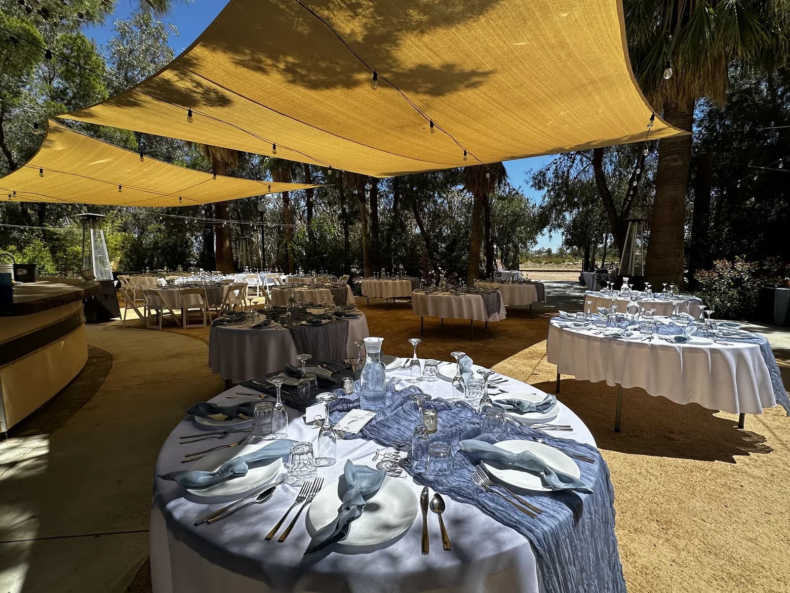 Tablescapes set for an event under the sail shades